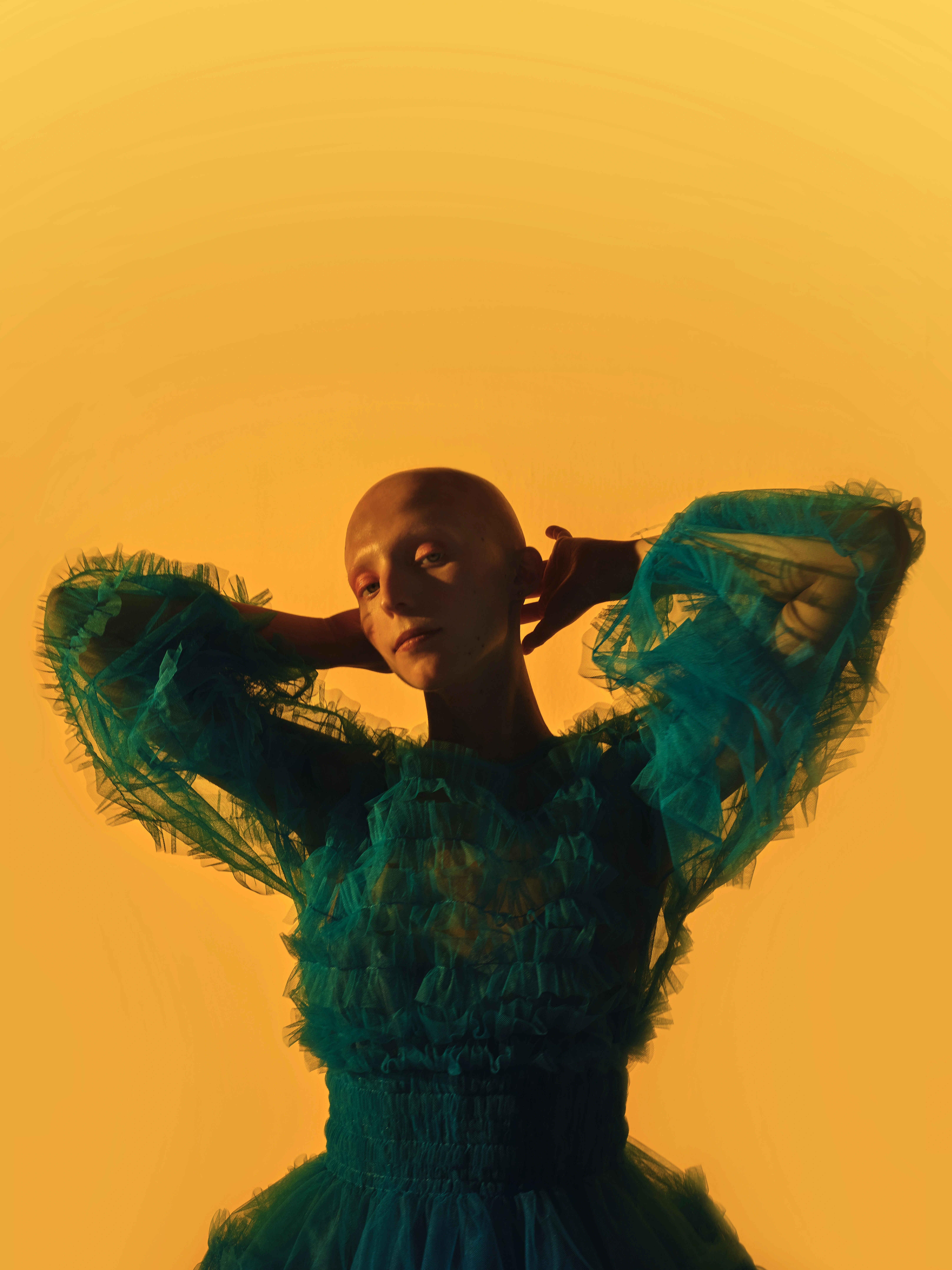 Model looks confidently at camera with bright yellow background.